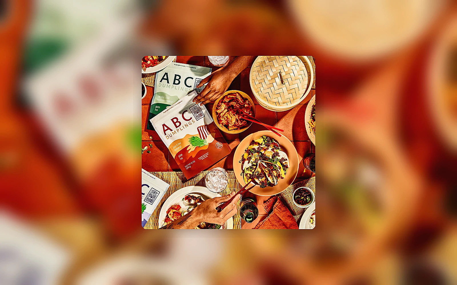Dumpling dinner table with sauce bowls and ABC Dumplings packs, photographed as a premium food editorial scene