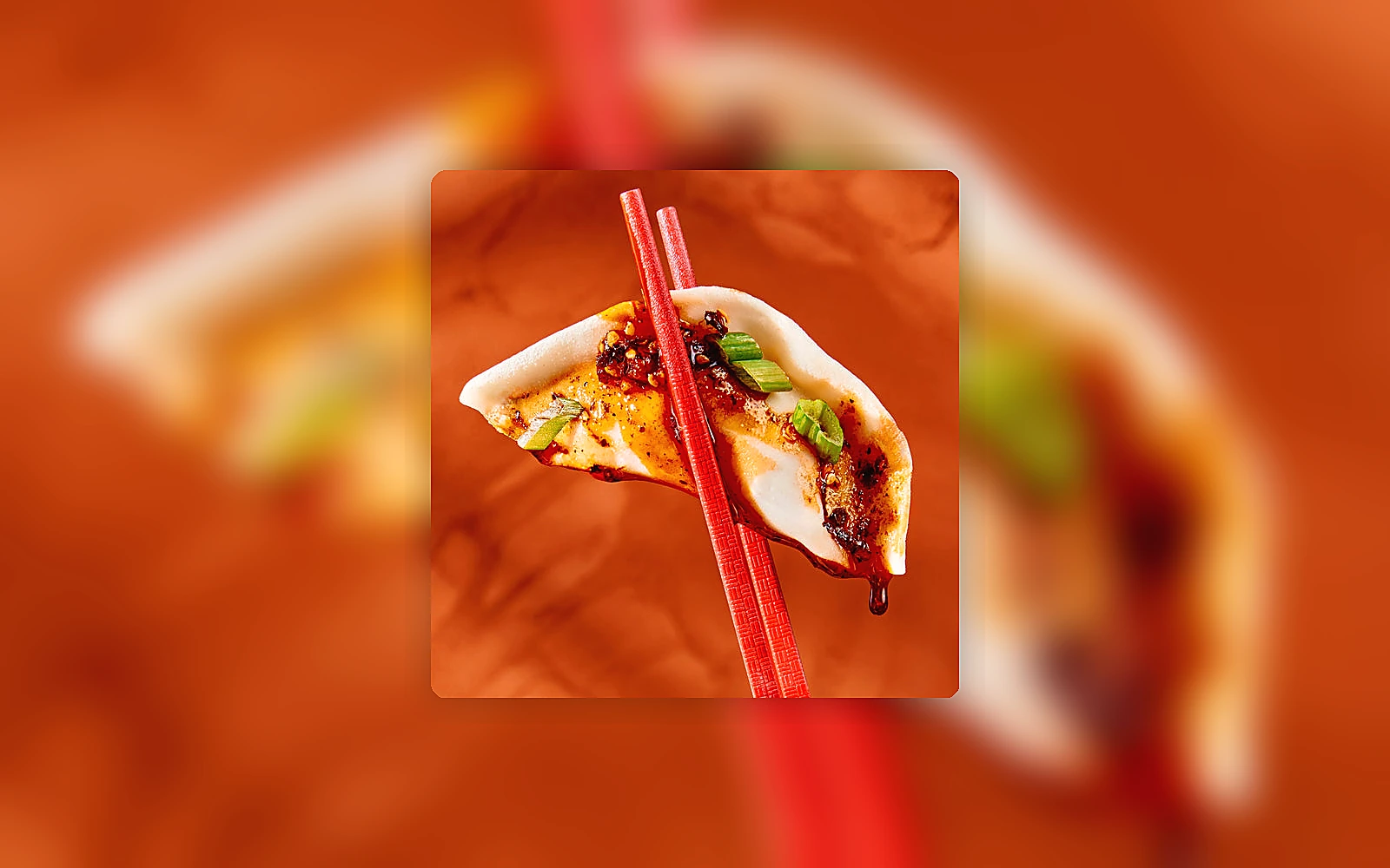 Close-up of a dumpling held with chopsticks showing wrapper texture and filling